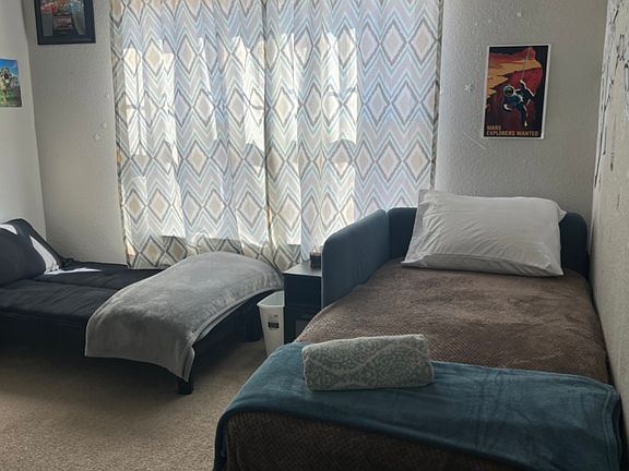 second bedroom with twin bed, futon, desk, and closet