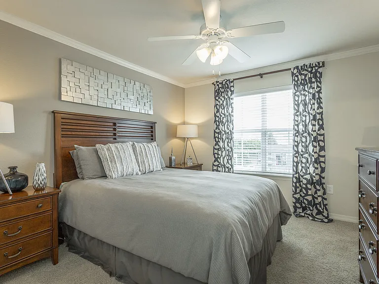Beautiful bedroom at Amberleigh Ridge with plush carpeting, overhead lighting, designer ceiling fan and large windows