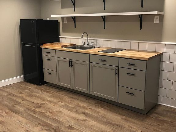 Eat in kitchen with new butcher block counter tops, cabinets, refrigerator, and tile backsplash.