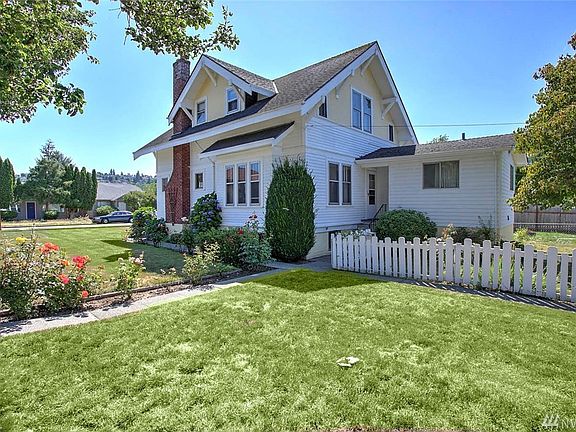 This view is from the back corner of the home and shows the white picket fence and beautiful rose garden. An addition was made to the back of the home and has a utility room and full bath.