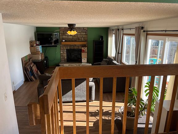 Sunken living room with lots of natural light, only window coverings included. Railing sets off upper dining area. New sliding glass door and windows.