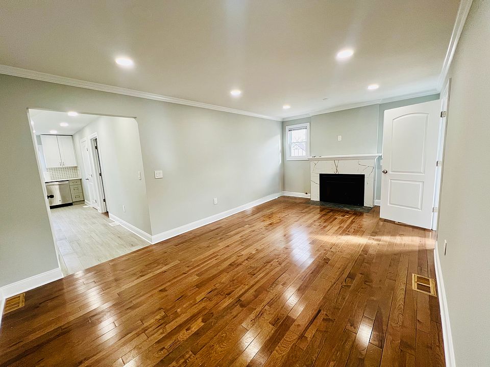 Different angle of Living room with working gas fireplace. Kitchen off hallway on left