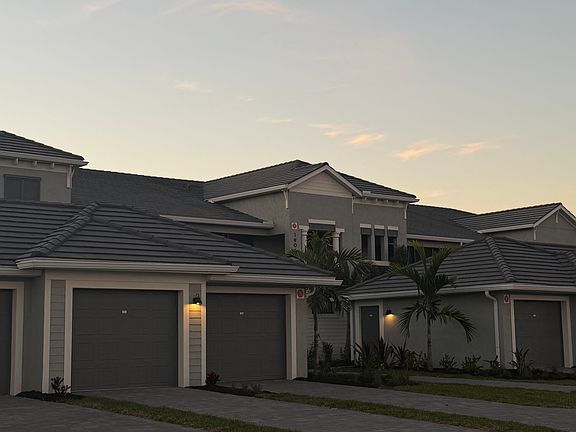 Beautiful two-story building with first-floor residence, private garage, and lush Florida landscaping in a gated country club setting.