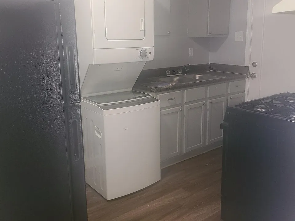 The kitchen has a brand-new black fridge and stove. Washer and dryer come in most units. Some units only have connections.
