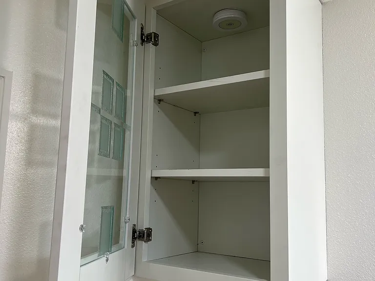 New Cabinet above toilet for storage and light comes on when dark automatic