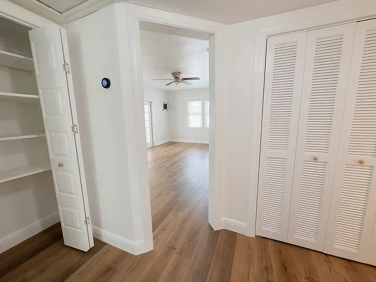 Hallway from the bedrooms to the living room with a closet.