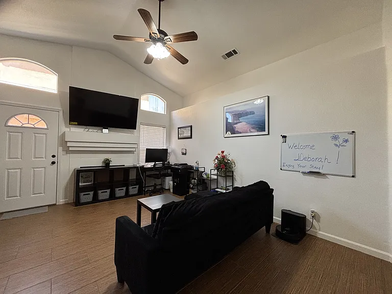 Living room with a working desk and big monitor ready for professional working from home.