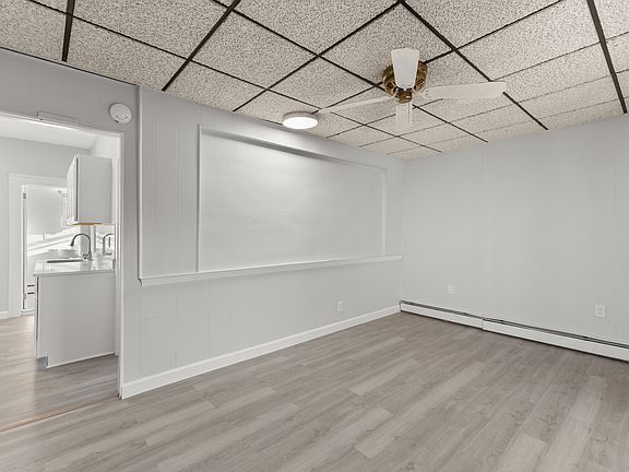 Spacious living room with modern flooring, neutral tones, and a stylish ceiling fan. Open layout offers flexibility for furniture and creates a bright, comfortable space for relaxing or entertaining.