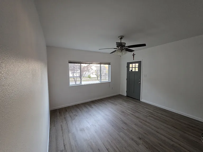 spacious front room with ceiling fan