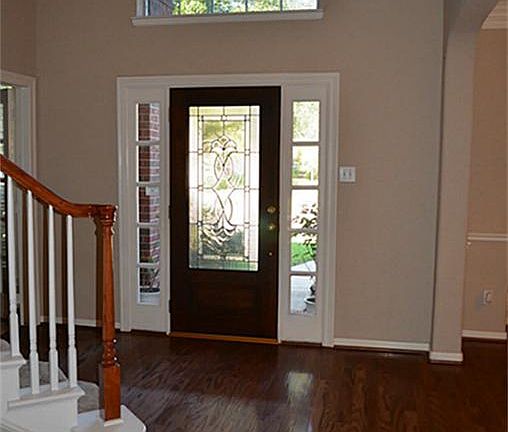 Two story entry with wood floors in entry and dining