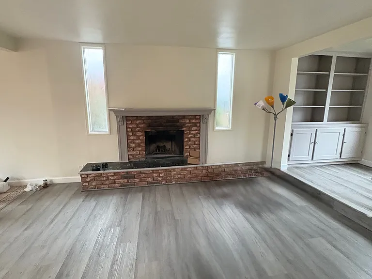 In the living room, across from the fireplace and looking at the entryway bookcase as well.