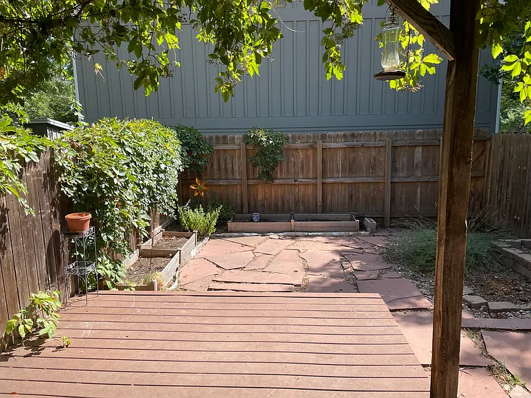 Backyard with planting beds and pergola and trex deck