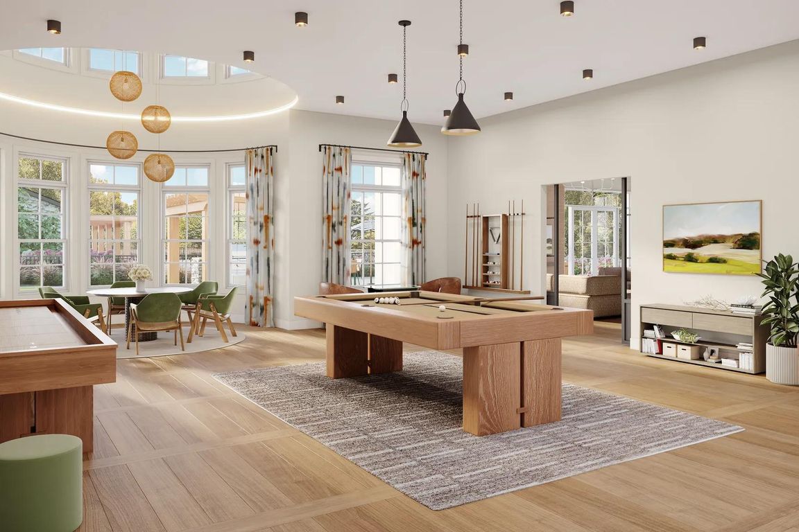 Game room with billiards, shuffleboard, poker table, and comfortable seating at Modera South Shore in Marshfield, MA.