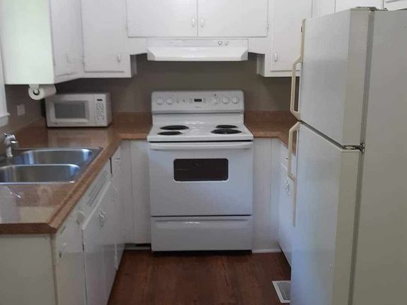 Galley kitchen with appliances furnished including dishwasher.