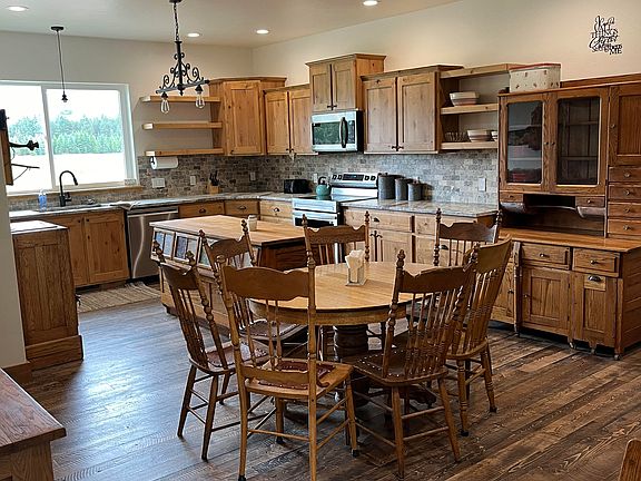 kitchen with antique bean counter from 1850 mercantile as island. Note gorgeous view of mountains and property from windows.