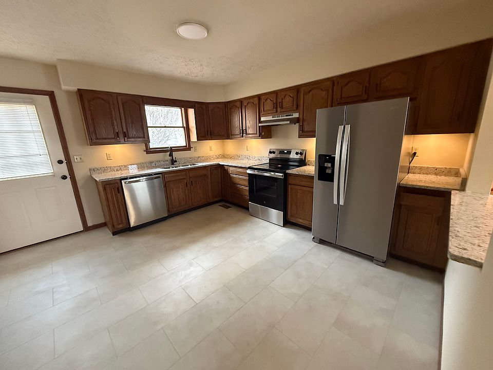 Very large kitchen with granite countertops, new stainless steel appliances, flooring, and under cabinet lighting.
