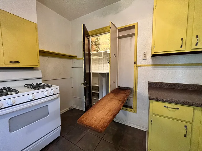 The original ironing board is functioning and can be brought down as needed. 
The pantry is spacious and has multiple levels of storage - as seen through the open pantry door.