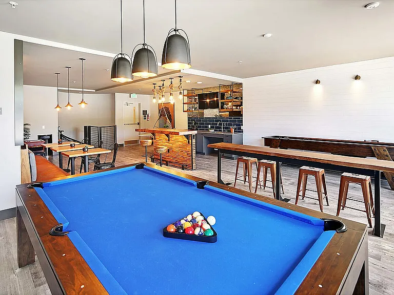 Unwind in this modern lounge with a billiards table and sleek bar setup.
