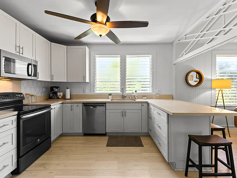 The kitchen is open to the living room and features plenty of storage and counter space, a ceiling fan, full size refrigerator with water station, oven, microwave and dishwasher. The kitchen is fully equipped.