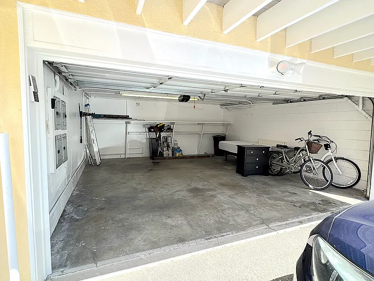 The shared garage. There is a parking space outside the enclosed garage for a visitor.
