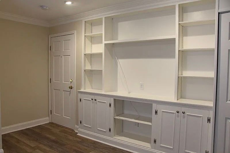 Living Area: unit entrance door on the left. Built-in shelves for storage and 51 51-inch TV.