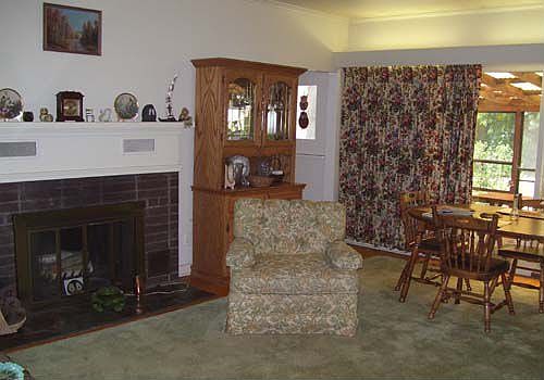 Vaulted living/dining rm has a fireplace & sliders to the enclosed porch