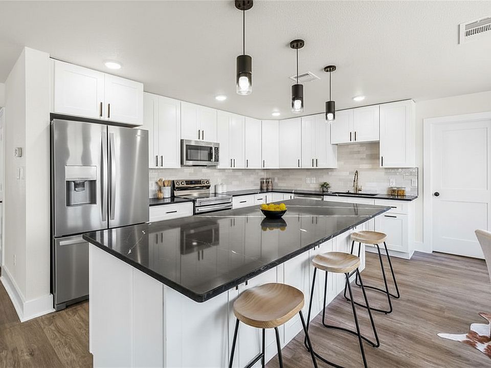 Fully remodeled kitchen with new stainless steel appliances (Fridge is being installed), HUGE island with lots of cabinet space and black quartz countertops