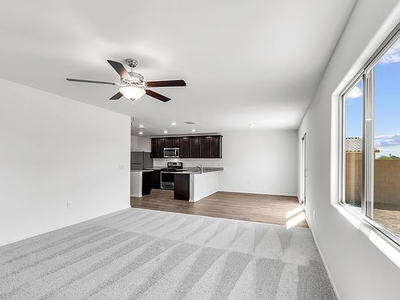 Large living room with a ceiling fan, adjacent to the dining area.
