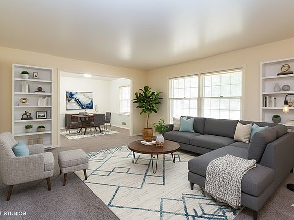 Formal living room has been virtually staged. The carpet throughout the house has been replaced with dark grey luxury vinyl floors.