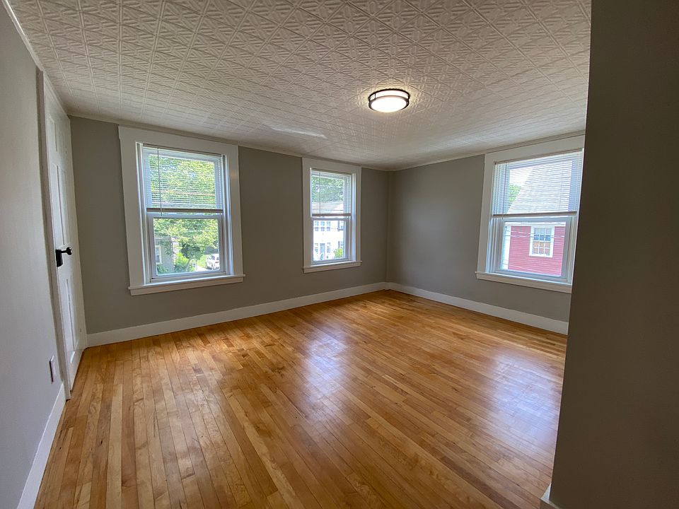 Bedroom with two closets, 3 windows and decorative ceiling. Hardwood floors. Closet on left wall.