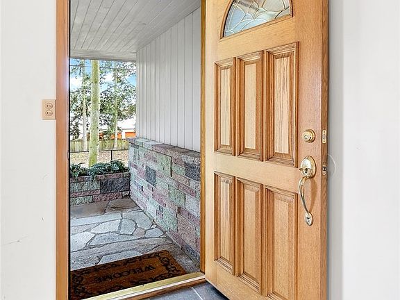 Beautiful wood door at covered entrance & slate tile entry welcomes you into the home and provides extra durability considering the NW weather.