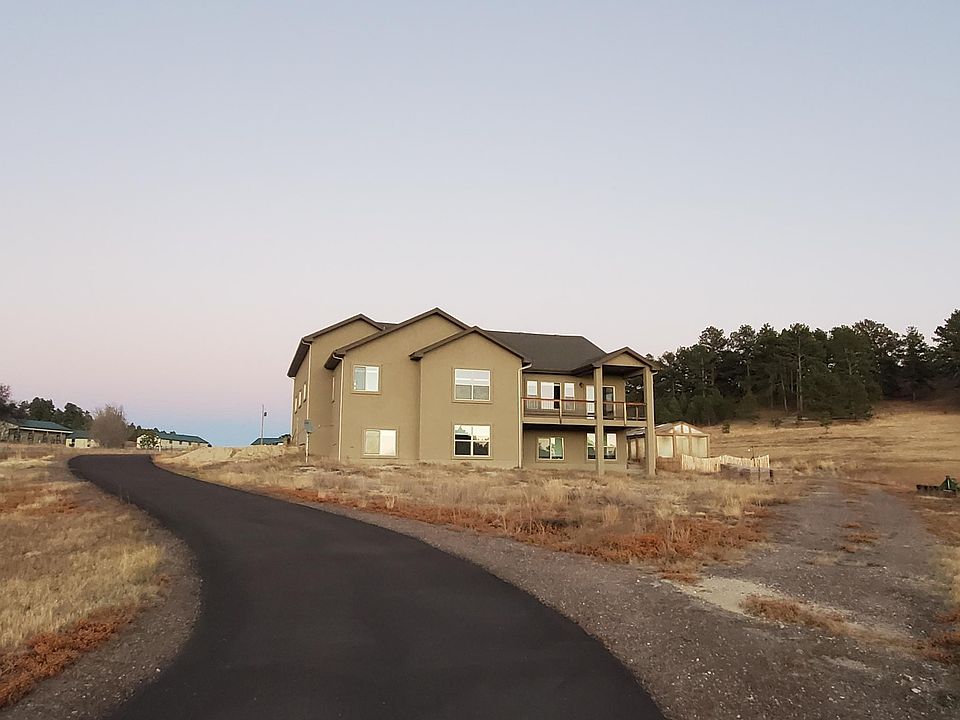 Looking east towards homestead park behind. over 4 acres with paved driveway. Greenhouse visible to right of house.