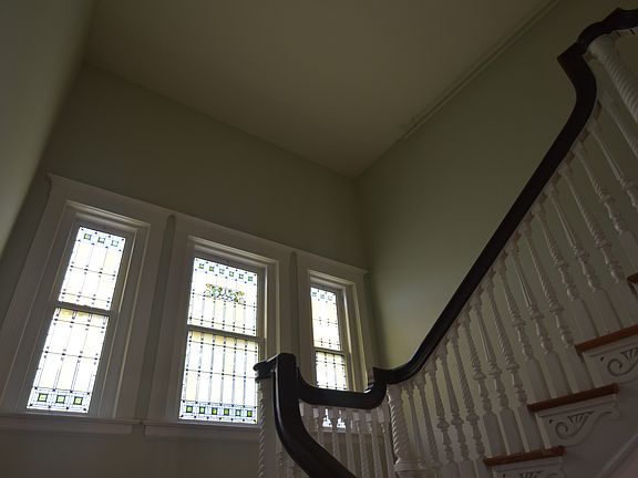 Large staircase with stained glass window in the landing