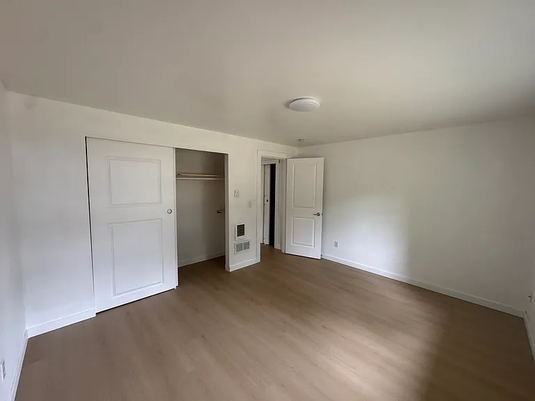 Bright secondary bedroom with new hard-surface flooring, a spacious closet, and plenty of natural light.