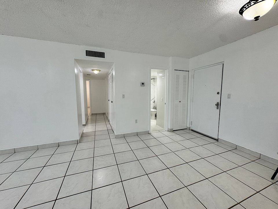 Living/dining showing entrance, 1/2 bath, and hallway to bedrooms and additional bathroom, with entrance to kitchen to the left of the hallway
