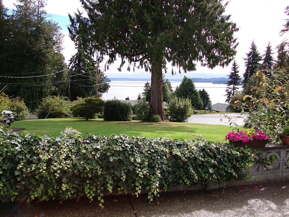 Looking out from the patio over looking the gardens, lawn and water.