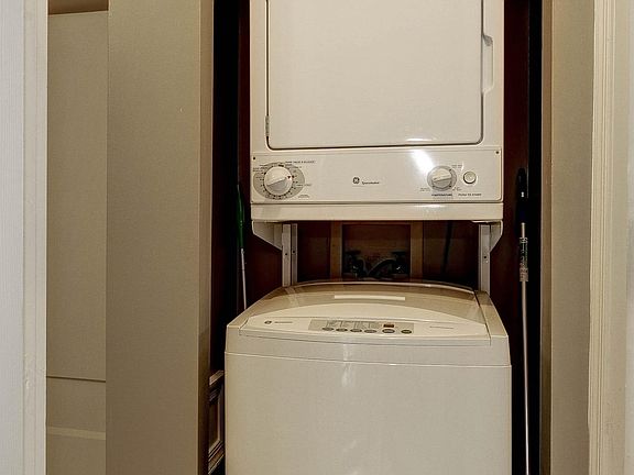 The stacked full size washer & dryer is located in the master bathroom.