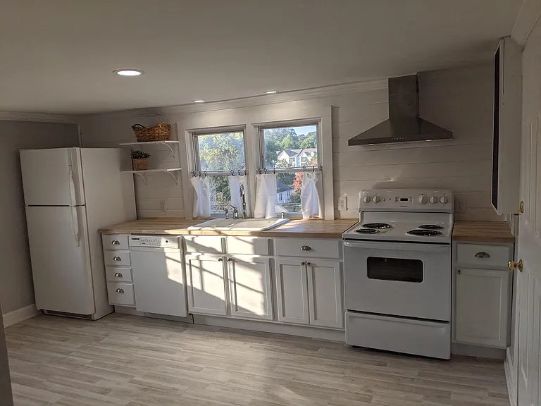 New cabinets and counter top. New wooden wall and floor. Secondary access to right is onto exterior stairs.