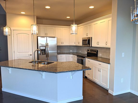 White Milarc cabinets with crown molding are throughout the kitchen and also in the primary bathroom suite.