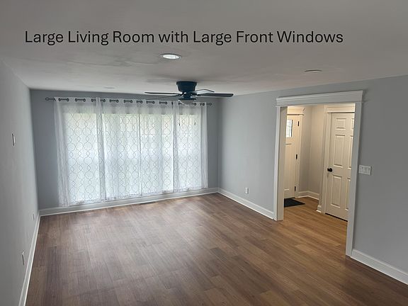 Large living room with huge windows. Entry hall and coat closet