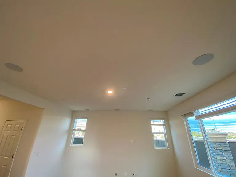 Great room displaying Five 6" in-ceiling speakers, 10" subwoofer, 6' of conduit for future wall mounted Panel TV