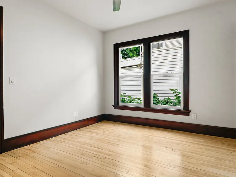 FIrst bedroom. It has a ceiling fan! look at the gleaming floors!