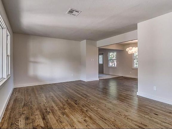 Living room. Lots of light with refinished hardwood floors and open floor plan.