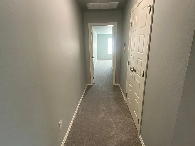 Hallway to master bed and double door linen closet