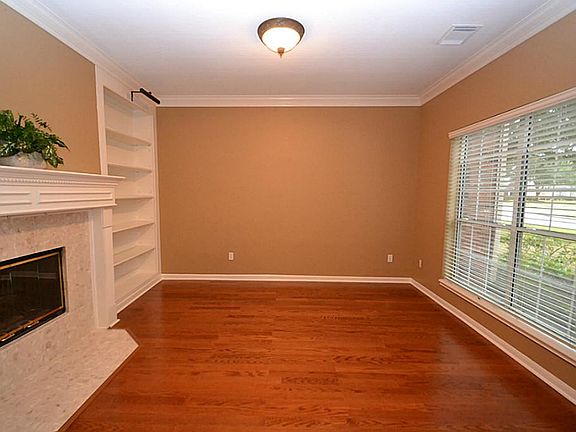 Living room accented by hardwood floors, double crown molding, built-in bookshelves and a double fir