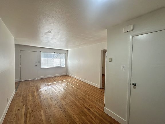 The living room, looking from far back towards the front door. Storage closet seen at right .