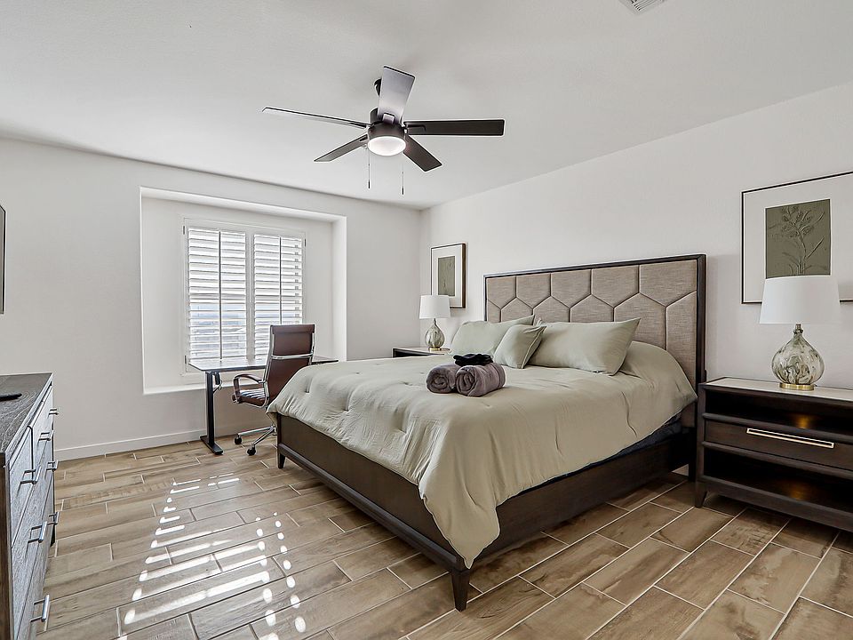 Comfortable bedroom with queen bed and work area.