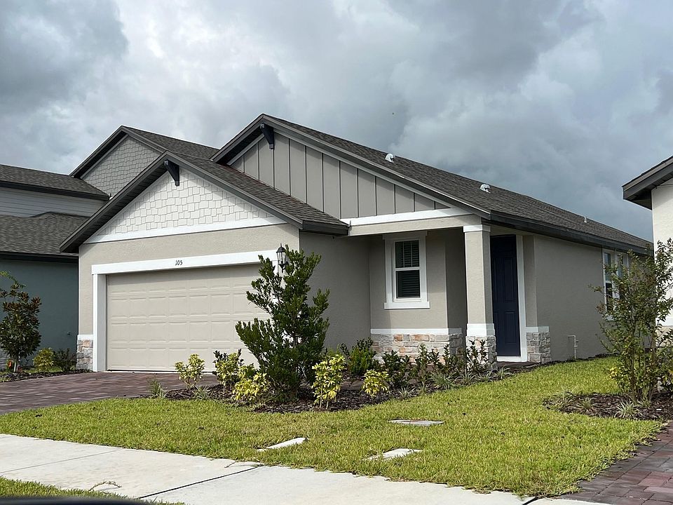 Front of home with paver driveway and attached 2 car garag