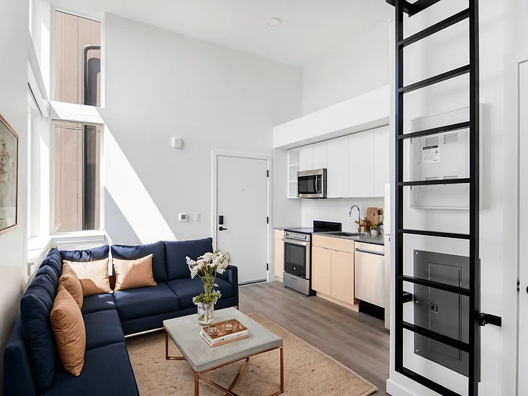 Enjoy the open kitchen with modern appliances and a cozy living room at Alt Capitol Hill.