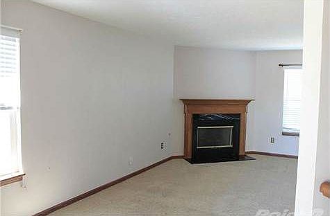 Great room with carpeted floor & gas fireplace.